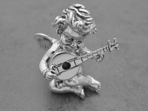 Auf dem Bild ist eine plastisch gestaltete Schutzengel Figur aus rhodiniertem Echtsilber zu sehen, die einen musikalischen Moment beim Spielen eines Instruments darstellt.