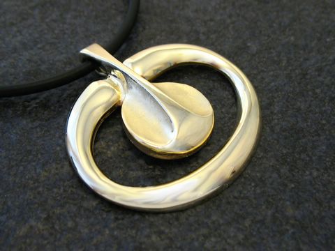 Designerschmuck aus Gold, eleganter Anhänger mit einem Durchmesser von 33 mm, hergestellt von Juwelier Harnisch, stilvolles und modernes Design auf schwarzem Hintergrund.