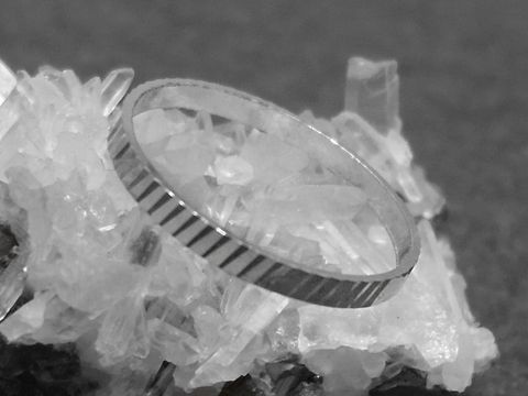 Silber Ring rhodiniert 2mm breit Größe 50 / 15,8mm auf einem Untergrund aus Kristallen, Hersteller Juwelier Harnisch, bis Größe 50 / 15,9.