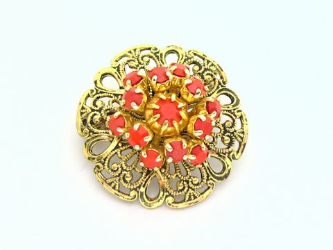 Damen Designer Brosche im Sexy City Look in Rot, rund, mit filigraner goldener Umrandung und strahlenden Schmucksteinen, Hersteller Juwelier Harnisch, idealer Modeschmuck.
