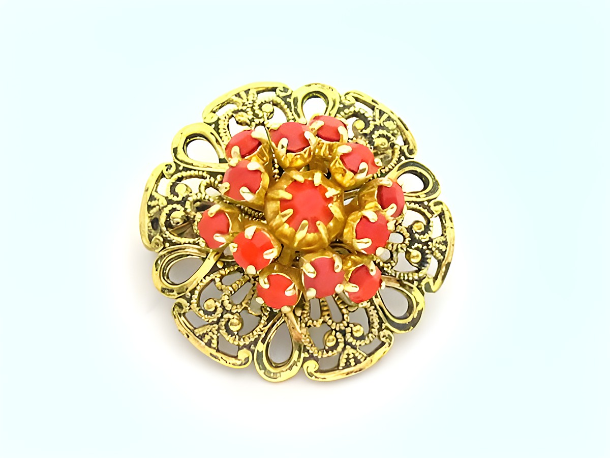 Damen Designer Brosche im Sexy City Look in Rot, rund, mit filigraner goldener Umrandung und strahlenden Schmucksteinen, Hersteller Juwelier Harnisch, idealer Modeschmuck.