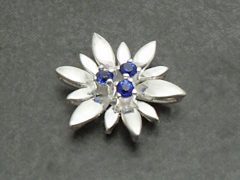 Silber Anhänger -City- 17x17mm mit einer Blüte aus synthetischem Spinell in der Mitte, umgeben von blattförmigen Elementen, hergestellt von Juwelier Harnisch, stilvoll und elegant.