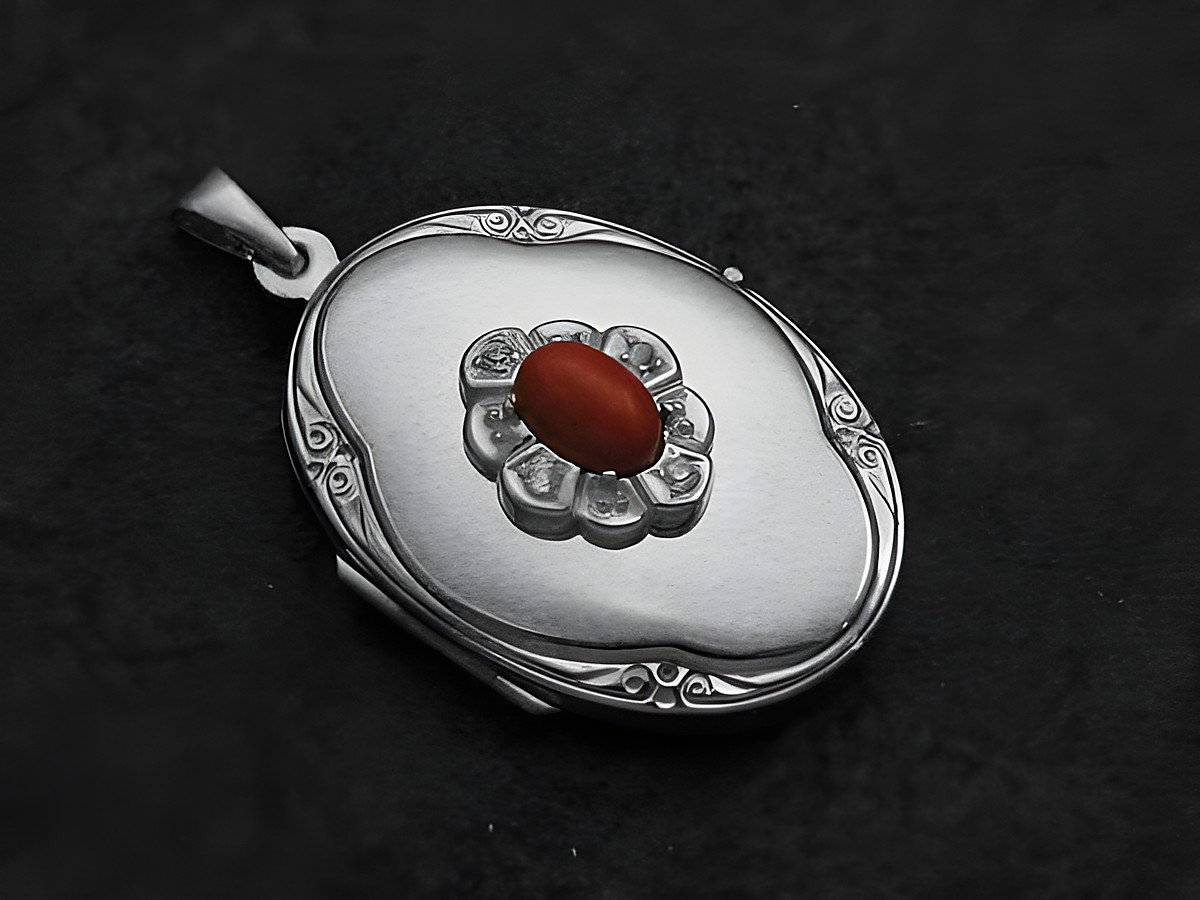 Ein ovales Medaillon aus Sterling Silber mit einem rot-braunen Jaspis-Cabochon in der Mitte, umgeben von Brillanten, hergestellt vom Juwelier Harnisch.
