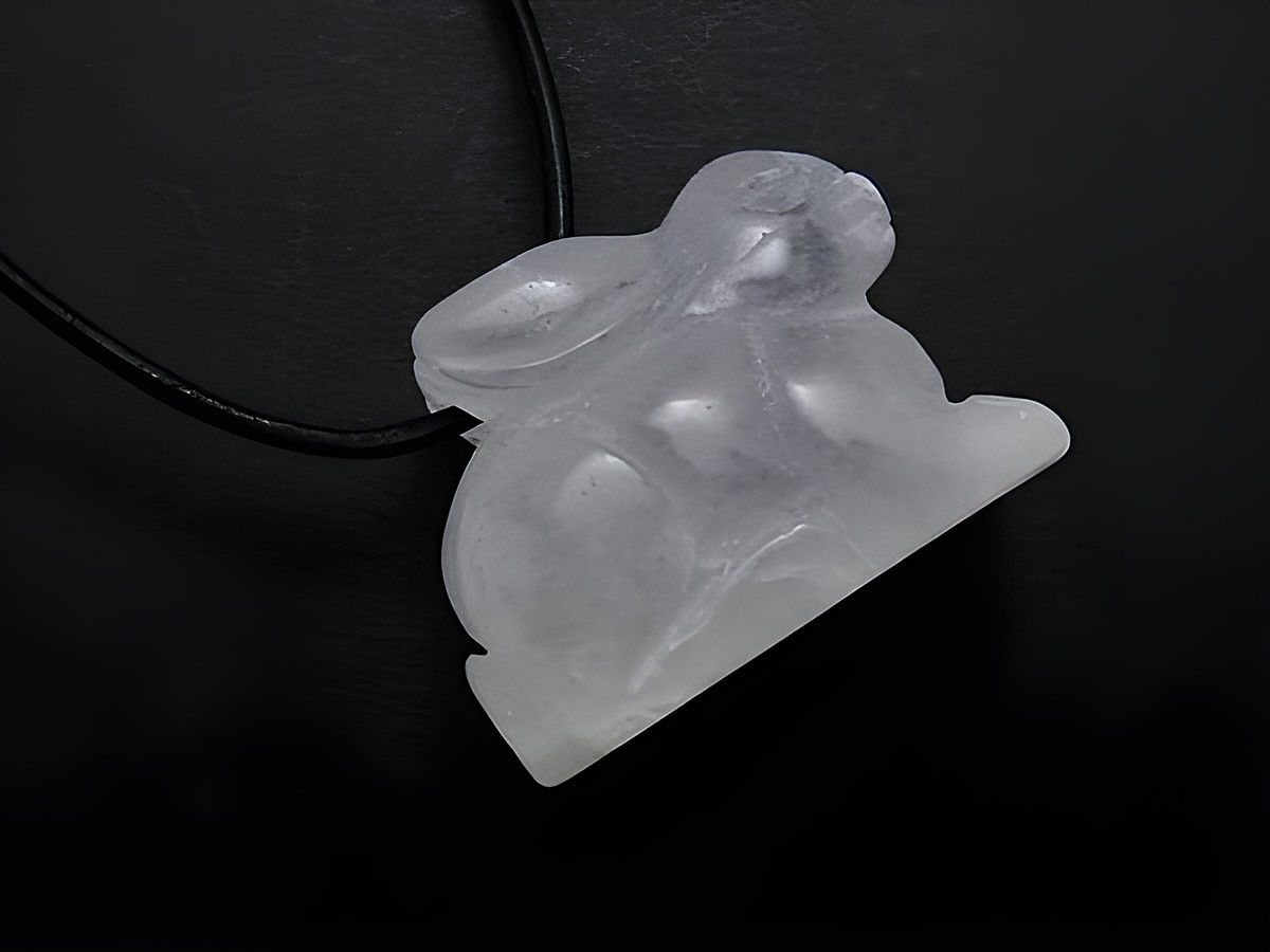 Steinfigur Anhänger aus Bergkristall in Form eines Hases mit einer 1 m langen Lederkette, hergestellt von Juwelier Harnisch, ideal für hochwertige Schmuckliebhaber.