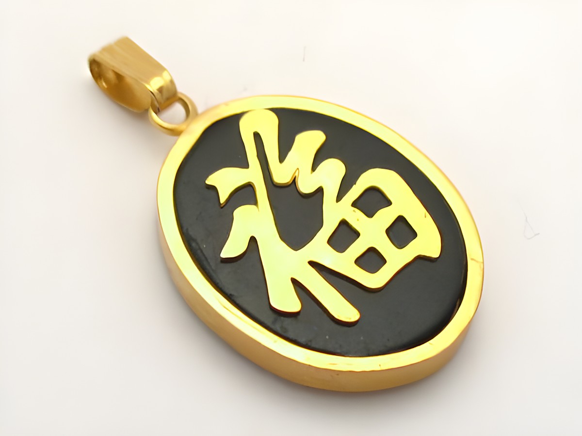 Ovaler China Onyx Anhänger in goldfarben mit einem symbolischen Motiv, hergestellt von Juwelier Harnisch, verziert mit Edelsteinen. Ideal für stilvolle Akzente.