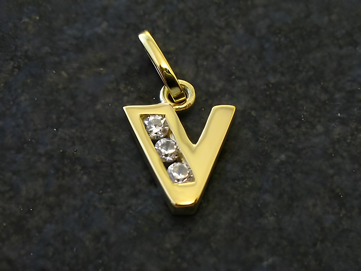 Goldener Anhänger in Form des Buchstabens V, verziert mit drei Zirkonia, Hersteller Juwelier Harnisch. Ideal als persönliches Schmuckstück oder Geschenk.