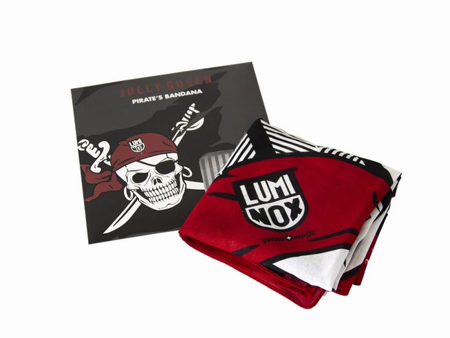Das Bild zeigt das Luminox Stirntuch Jolly Roger Bandana, das auf einem stilvollen Hintergrund präsentiert wird. Die Bandana ist rot und weiß mit einem markanten Design und dem Luminox Logo.