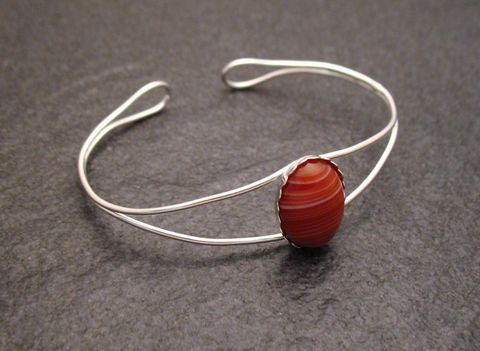 Roter Sardonyx Cabochon in einem filigranen Sterling Silber Armreif mit einem Umfang von 17 cm, gefertigt von Juwelier Harnisch. Elegantes und zeitloses Schmuckstück.