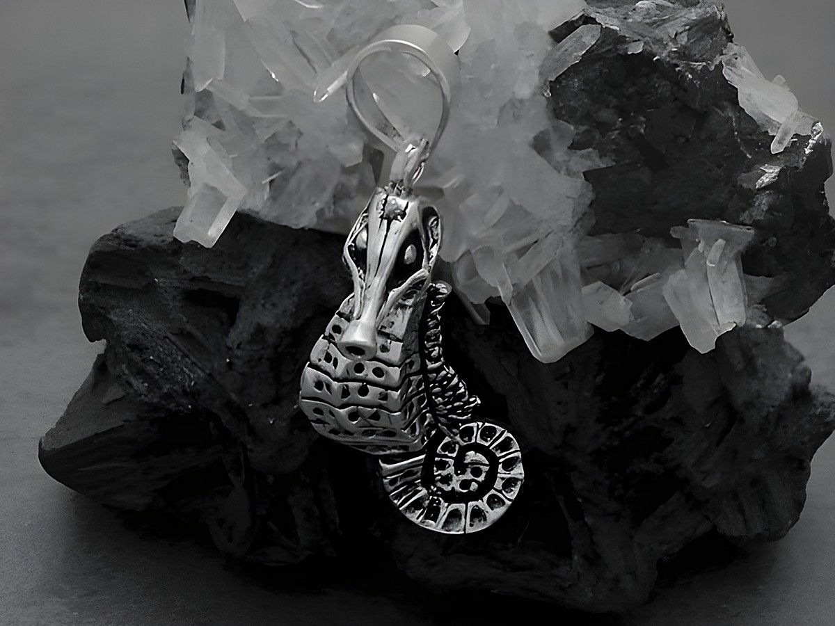 Seepferdchen Anhänger aus Sterling Silber mit beweglichem Kopf und Schwanz, gefertigt von Juwelier Harnisch, ein schöner Glücksbringer, vor einem schwarzen Naturstein platziert.