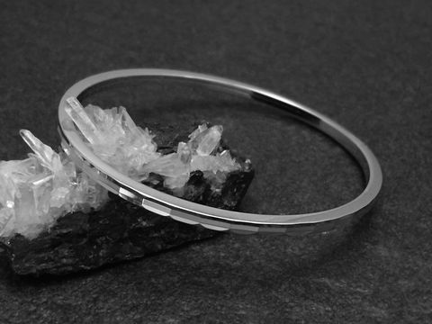Silber Armreifen mit Diamantschliff und einer Breite von 3 mm, rhodiniert, in der Größe 17,5 cm, Hersteller Juwelier Harnisch, elegant auf schwarzem Hintergrund präsentiert.