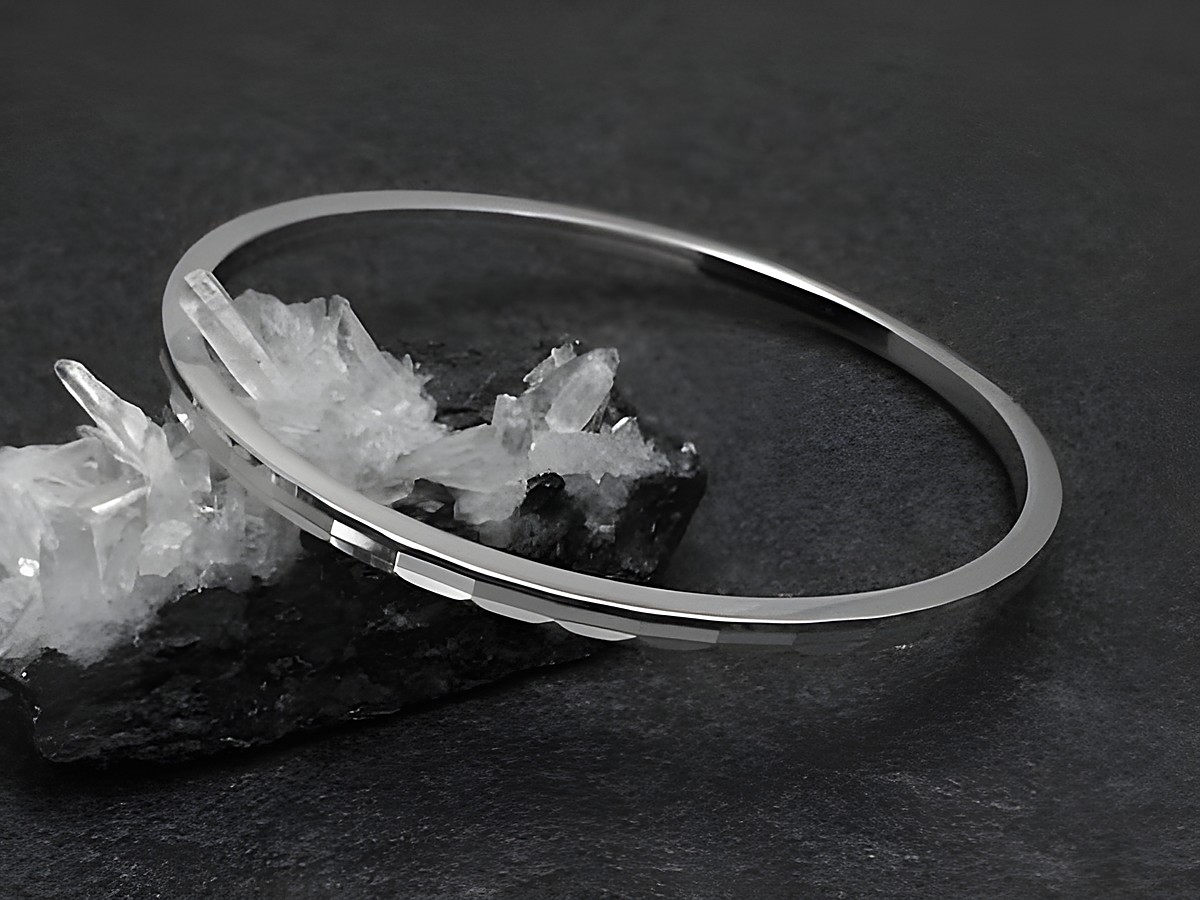 Silber Armreifen mit Diamantschliff und einer Breite von 3 mm, rhodiniert, in der Größe 17,5 cm, Hersteller Juwelier Harnisch, elegant auf schwarzem Hintergrund präsentiert.