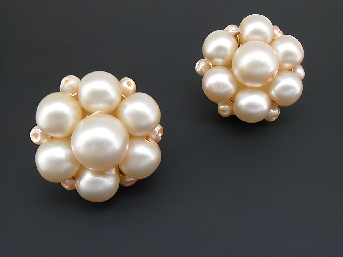 Ohrclip in hellrosa blumigem Design mit goldfarbenen synthetischen Zuchtperlen, Hersteller Juwelier Harnisch, elegant und auffällig.
