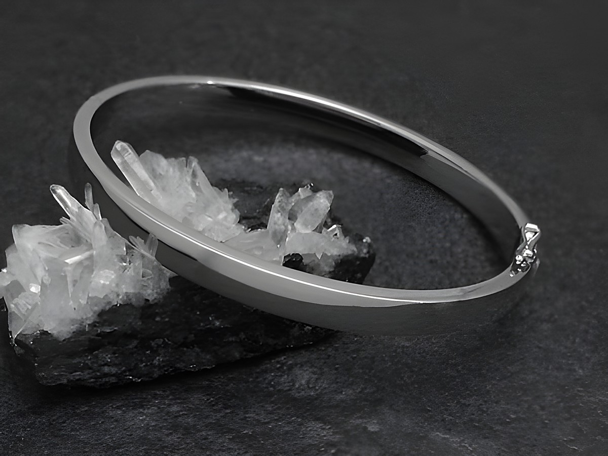 Silber Armreifen - blank - 5,8 mm - rhodiniert - 18 cm, Hersteller: Juwelier Harnisch, stilvoll abgebildet auf einem dunklen Untergrund mit Kristallen.