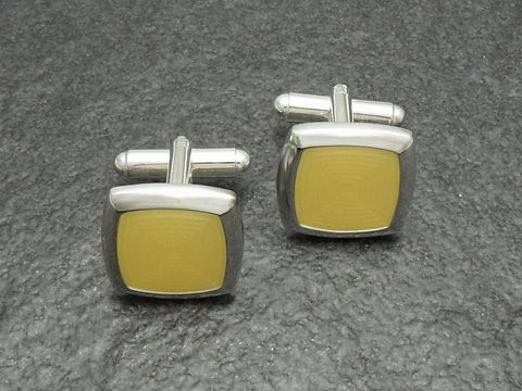 Manschettenknöpfe in modernem Design, silberfarben mit gelbem Inlay, hergestellt von Juwelier Harnisch, perfekt für stilvolle Anlässe.