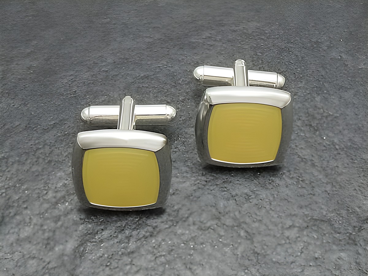Manschettenknöpfe in modernem Design, silberfarben mit gelbem Inlay, hergestellt von Juwelier Harnisch, perfekt für stilvolle Anlässe.