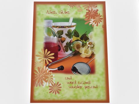 Eine Genesungskarte mit dem Text Alles Gute und werd schnell wieder gesund, darauf eine Medizinflasche, eine Tasse, Blumen und ein Stethoskop, Hersteller Juwelier Harnisch, Genesungskarten.