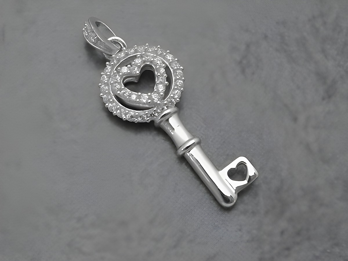 Schlüssel mit Herz Anhänger aus rhodiniertem Sterling Silber, verziert mit Zirkonia, symbolisch in weiß, Hersteller Juwelier Harnisch, elegantes Design.