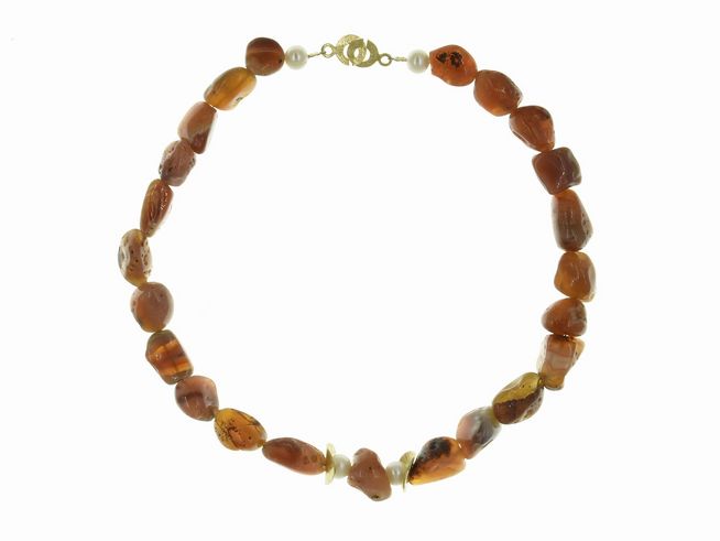 Eine elegante Steinkette aus Karneol in Braun- und Weißtönen, kombiniert mit Süßwasser-Zuchtperlen. Die Kette hat eine Länge von 44 cm und schließt mit einem Silberverschluss. Juwelier Harnisch.