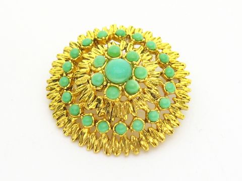 Brosche im Sexy City Look in smaragdgrün und goldfarben, rund gestaltet mit zahlreichen kleinen türkisen Steinen, hergestellt von Juwelier Harnisch, ideal für elegante Outfits.