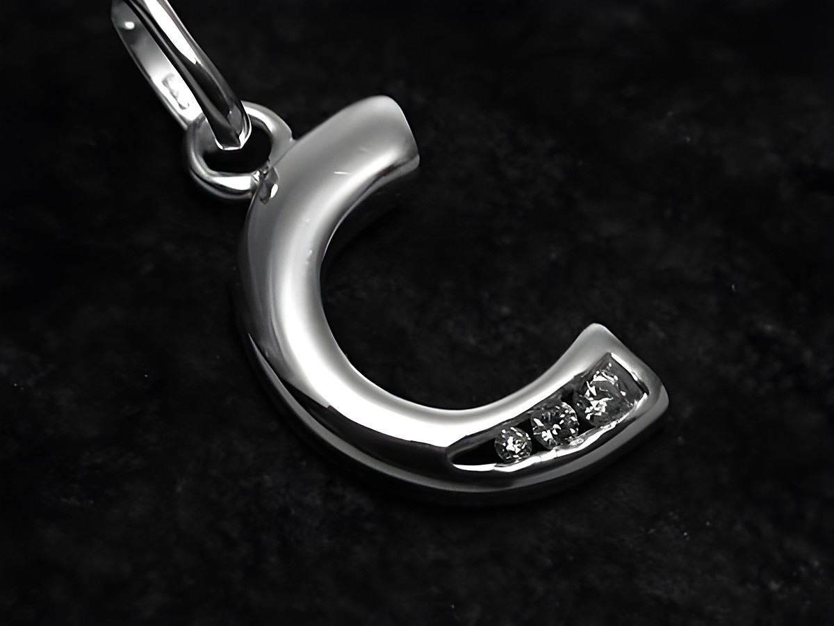 C Buchstaben Anhänger aus Sterling Silber mit Zirkonia, Hersteller Juwelier Harnisch, glänzende Oberfläche und funkelnde Steinchen in der Mitte, stilvolles Schmuckstück.