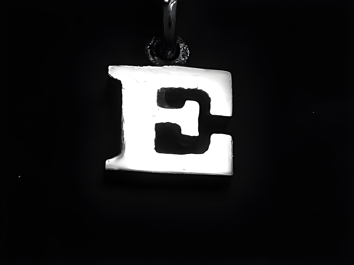 E 925 Sterling Silber Druck-Buchstaben Anhänger, Hersteller Juwelier Harnisch, stilvolles Design des Buchstabens E auf schwarzem Hintergrund.