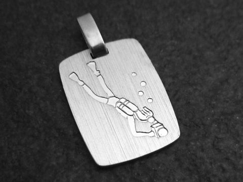 Silber Anhänger mit einer Gravur eines Tauchers, der unter Wasser schwimmt. Der Anhänger hat eine rechteckige Form und zeigt Blasen, die um den Taucher herum aufsteigen.