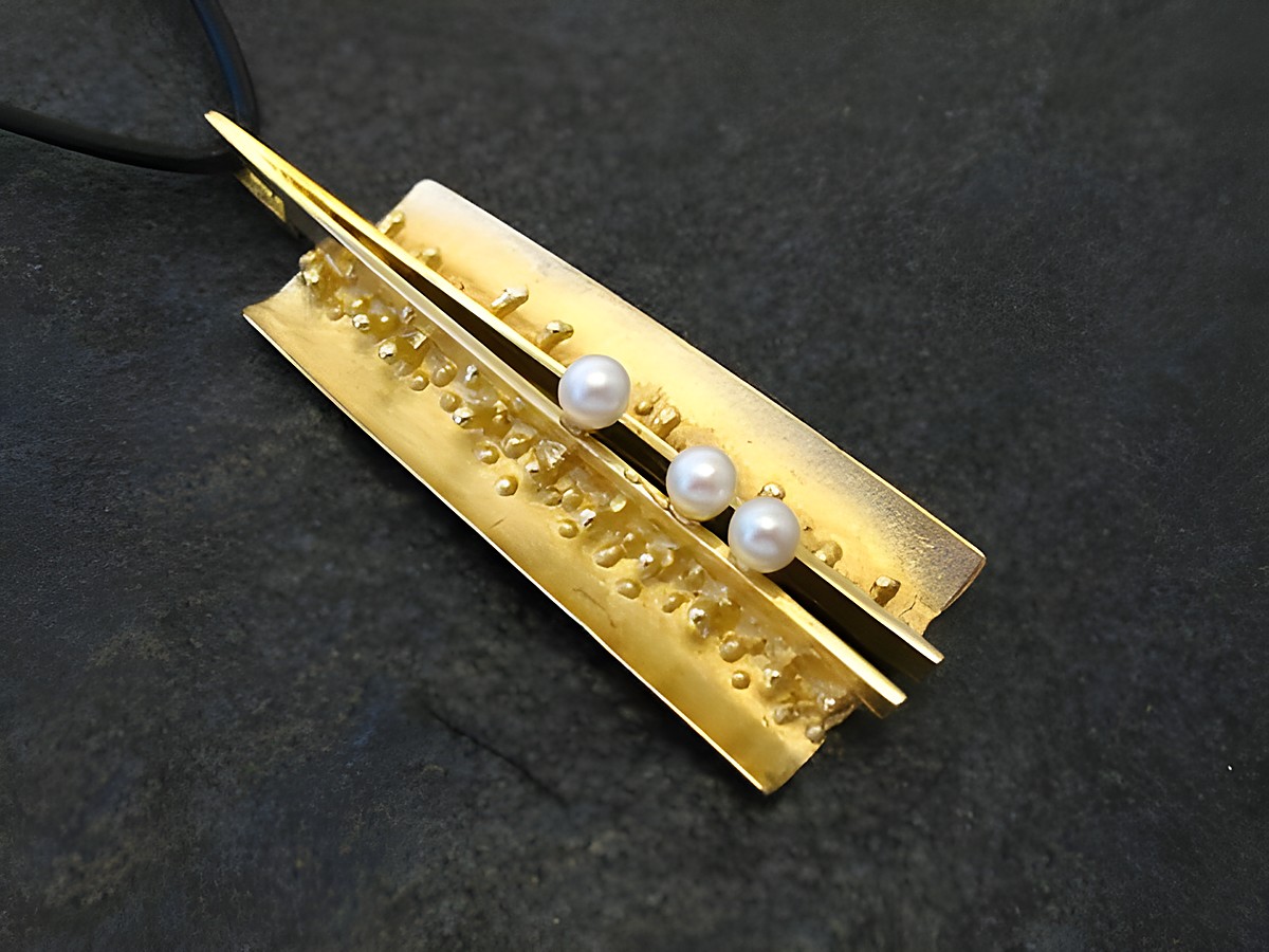 Gold Anhänger mit einer Länge von 53 mm, verziert mit zwei Perlen und einem strukturierten Design. Hergestellt von Juwelier Harnisch, ideal als eleganter Schmuck für besondere Anlässe.