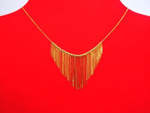 Collier Kette 333 Mittelteil kleine Kettchen vorne 42cm von Hersteller Juwelier Harnisch, das goldene Collier hat einen eleganten, fransigen Mittelteil und liegt auf einem roten Untergrund.