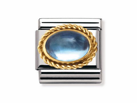 Die NOMINATION Classic Kordel in Blau Topas mit Goldrand hat einen ovalen, blauen Stein, der von einem goldenen, geflochtenen Rahmen umgeben ist, auf einem silbernen Hintergrund.