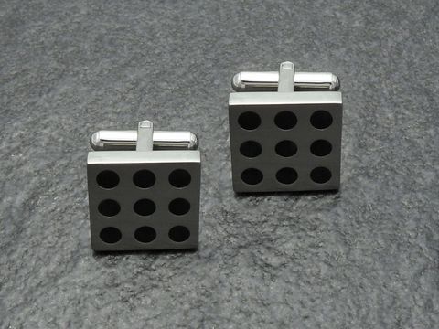 Manschettenknöpfe aus Edelstahl mit neun schwarzen Punkten, hergestellt von Juwelier Harnisch, rechteckiges Design, modern und elegant für festliche Anlässe.
