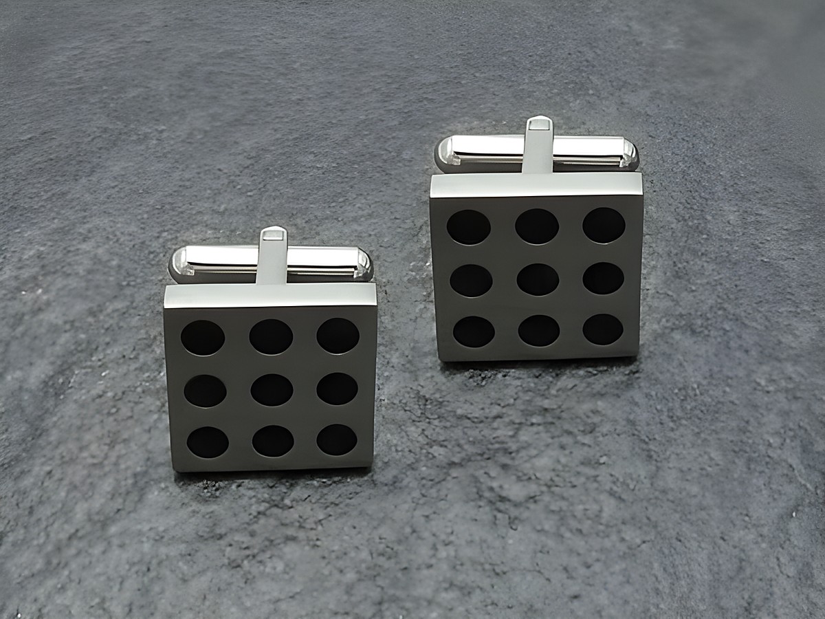Manschettenknöpfe aus Edelstahl mit neun schwarzen Punkten, hergestellt von Juwelier Harnisch, rechteckiges Design, modern und elegant für festliche Anlässe.