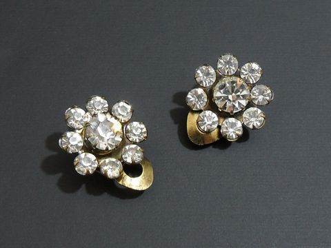 Strass Ohrclip grazil in Weiß und goldfarben, hergestellt von Juwelier Harnisch, verziert mit glitzernden Strasssteinen. Ideal für elegante Anlässe und ein Hauch von Glamour.