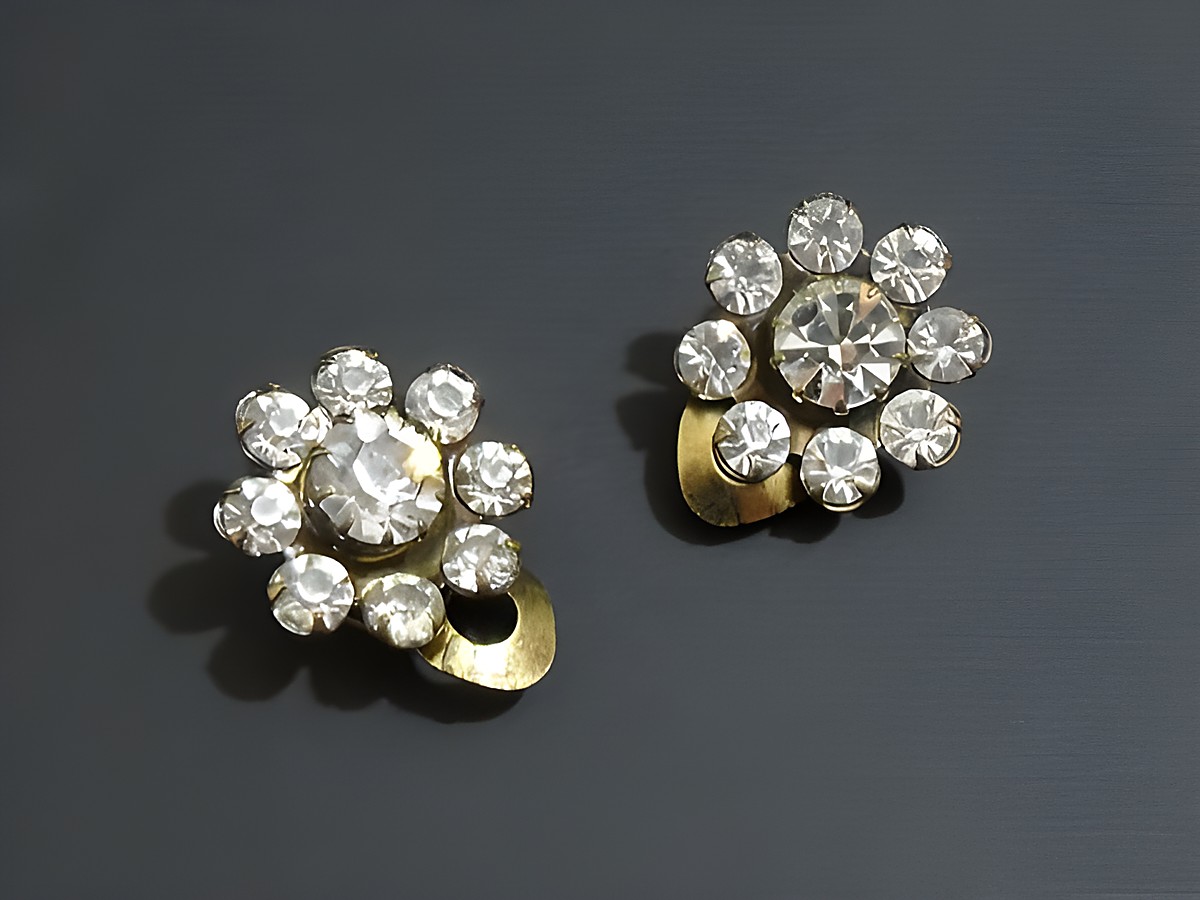 Strass Ohrclip grazil in Weiß und goldfarben, hergestellt von Juwelier Harnisch, verziert mit glitzernden Strasssteinen. Ideal für elegante Anlässe und ein Hauch von Glamour.