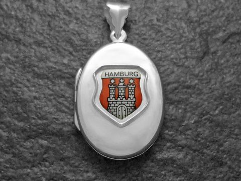 Silbernes Medaillon mit dem Wappen von Hamburg, welches eine rote Hintergrundfarbe und die charakteristische Stadtbefestigung zeigt, gefertigt von Juwelier Harnisch in Hamburg.