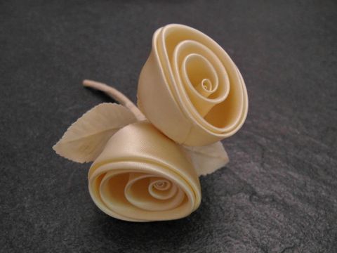 Traumhafter Haarschmuck aus pastellgelben Satin-Rosen mit zarten Blüten und Blättern, ideal für besondere Anlässe, Hersteller: Juwelier Harnisch, ergänzend eine elegante Brosche.