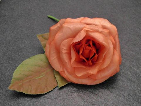 Haarschmuck mit einer opulenten Brosche in Form einer orangefarbenen Textilrose, Hersteller Juwelier Harnisch, ideal als Blumenhaarschmuck für besondere Anlässe.