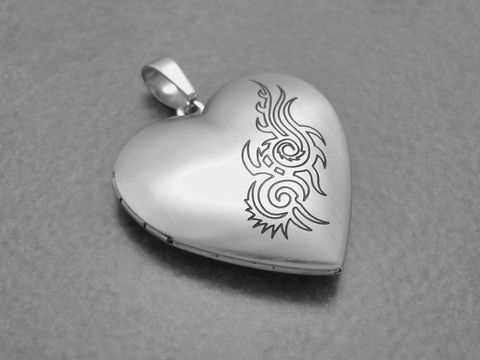 Medaillon aus Edelstahl - Herz mit mattem Muster von Juwelier Harnisch, dekoriert mit einem geschwungenen Design auf der Vorderseite, ideal für persönliche Erinnerungen und Schmuckliebhaber.