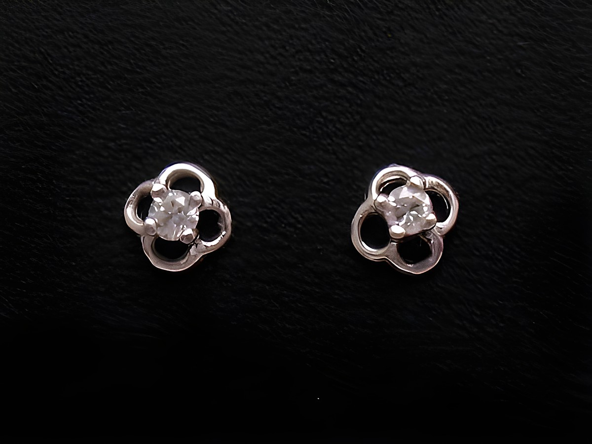 Ohrringe aus Weißgold 585 mit einem Diamanten von 0,06 ct W/P, von Juwelier Harnisch, filigranes Design mit blütenähnlicher Form und funkelndem Stein in der Mitte.