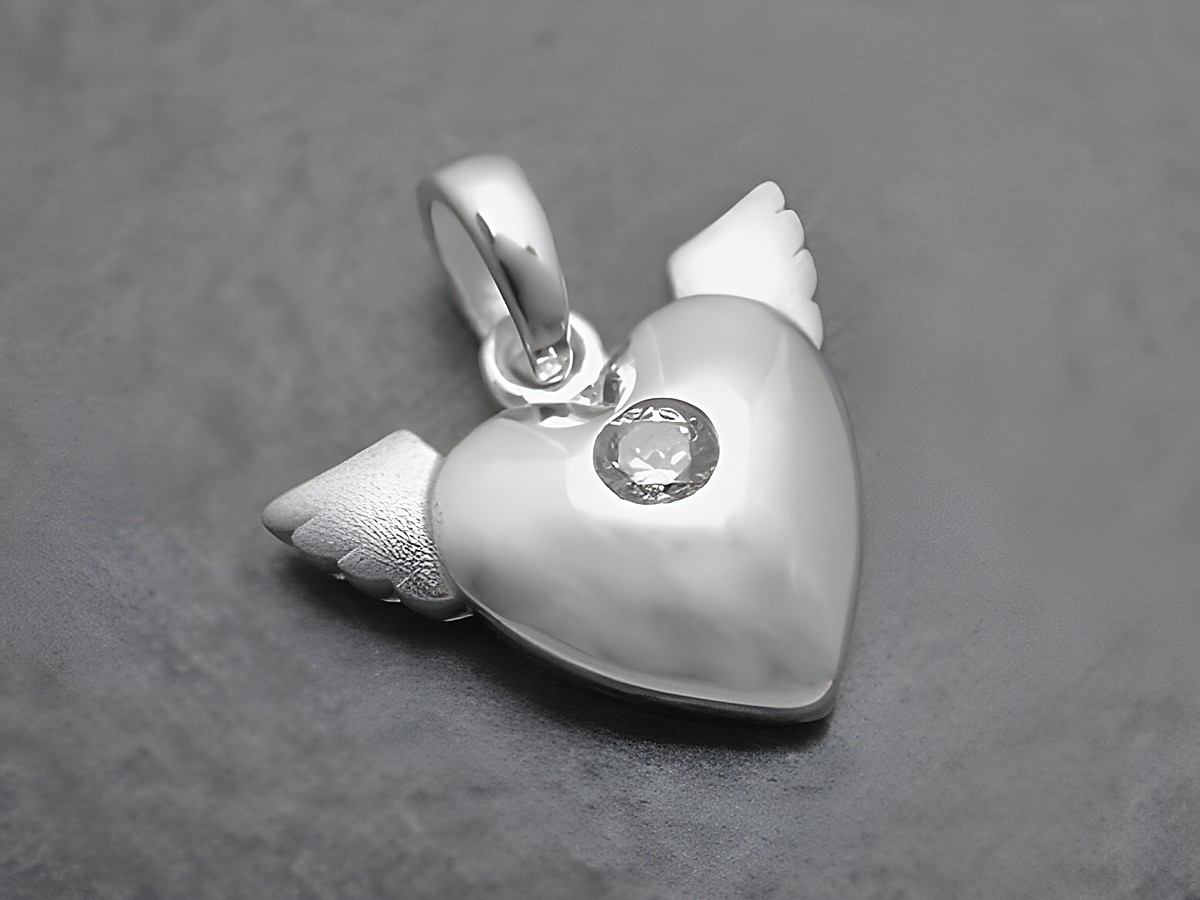 Ein romantischer Anhänger in Herzform mit Flügeln aus Sterling Silber, verziert mit einem weißen Zirkonia. Ideal für besondere Anlässe und als Geschenk. Hergestellt von Juwelier Harnisch, Perlen & Steine.