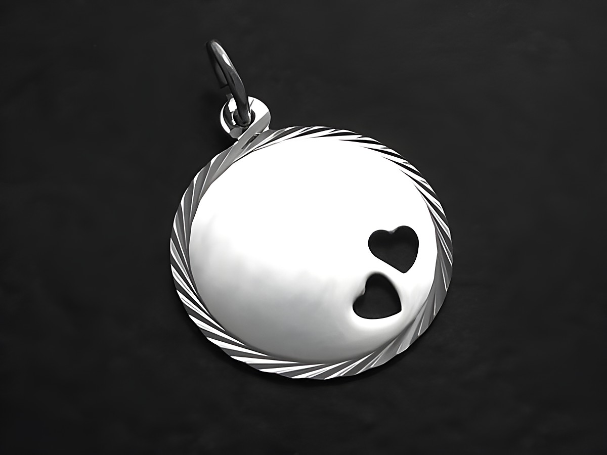 Die Gravurplatte Anhänger aus Sterling Silber ist rund mit einem eingearbeiteten Herzchen-Design und einem schlichten, gedrehten Rand. Hersteller ist Juwelier Harnisch.