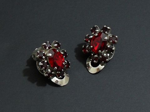 Strass Ohrclip anmutig in rubinrot und silberfarben, hergestellt vom Juwelier Harnisch, kombiniert elegantes Design mit funkelnden roten Steinen. Ideal für festliche Anlässe.