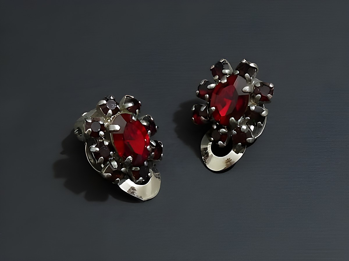 Strass Ohrclip anmutig in rubinrot und silberfarben, hergestellt vom Juwelier Harnisch, kombiniert elegantes Design mit funkelnden roten Steinen. Ideal für festliche Anlässe.