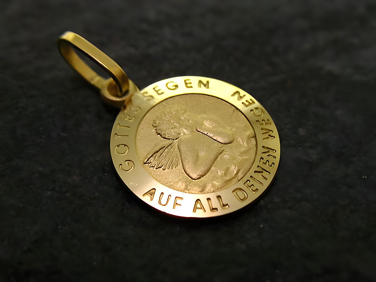 Goldener Anhänger mit einem Schutzengel-Motiv, umgeben von der Gravur Gottes Segen und Auf all deinen Wegen, Hersteller Juwelier Harnisch, ideal als Geschenk oder Schmuckstück.