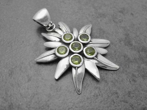 Edelweiß Silber Anhänger 43,4 mm mit Alpenblume und Peridot, das Schmuckstück zeigt filigrane Blütenblätter und grüne Steine, hergestellt von Juwelier Harnisch.