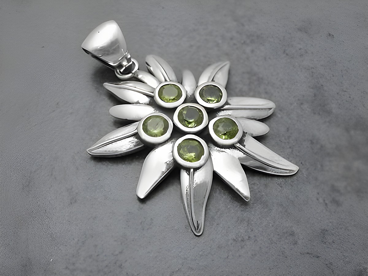 Edelweiß Silber Anhänger 43,4 mm mit Alpenblume und Peridot, das Schmuckstück zeigt filigrane Blütenblätter und grüne Steine, hergestellt von Juwelier Harnisch.