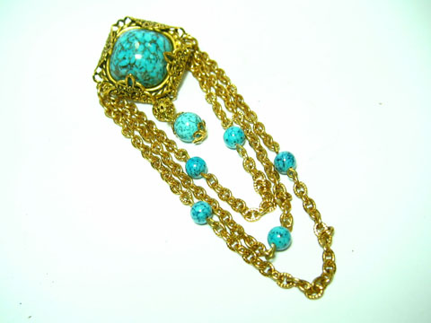 60361-0 Wunderschöne Brosche in Türkis mit gefasstem Hauptstein, umgeben von goldfarbenen Kettengliedern und zusätzlichen türkisfarbenen Perlen, neu vom Juwelier Harnisch.