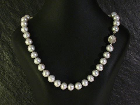 Perlenkette 45 cm grau aus Süßwasser Zuchtperlen mit einem funkelnden Verschluss, präsentiert auf einer eleganten Schaufensterpuppe. Hersteller Juwelier Harnisch, bunt.