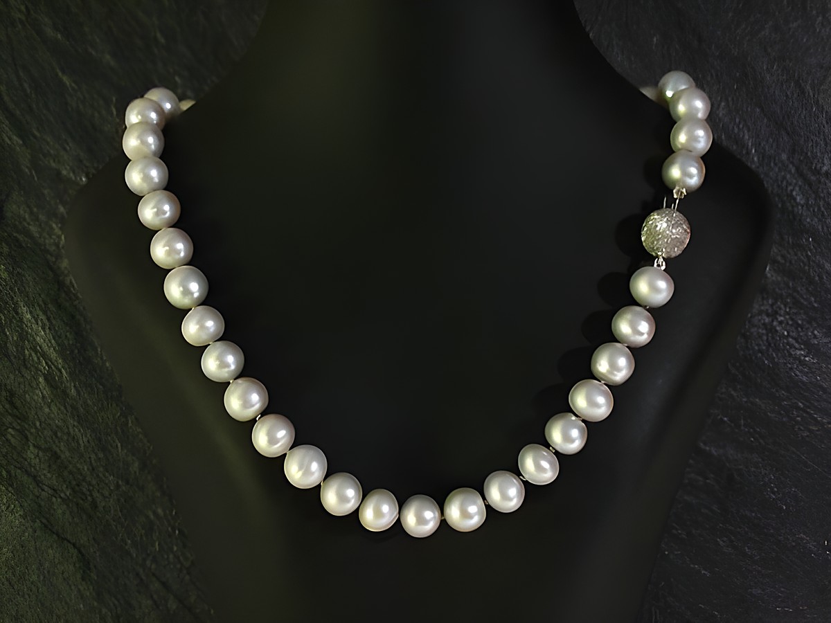Perlenkette 45 cm grau aus Süßwasser Zuchtperlen mit einem funkelnden Verschluss, präsentiert auf einer eleganten Schaufensterpuppe. Hersteller Juwelier Harnisch, bunt.