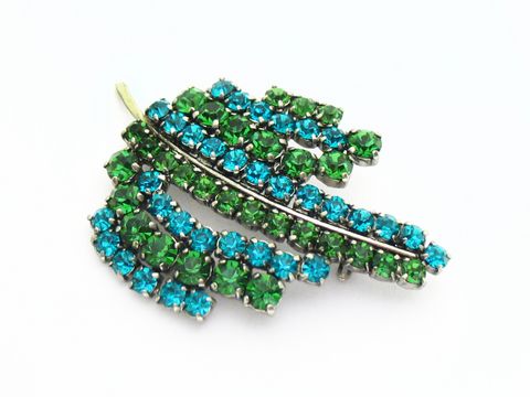 Brosche Sexy City Look Einzelstück in Grün Blau von Juwelier Harnisch, geschmückt mit Strasssteinen, die in verschiedenen Grüntönen und Blau funkeln, ideal für stylische Akzente.
