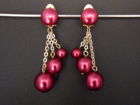 Himbeerrote Ohrclips aus Kunstharz mit goldfarbenen Akzenten, elegant und zeitlos gestaltet, bieten eine stilvolle Ergänzung für jedes Outfit, Hersteller Juwelier Harnisch.
